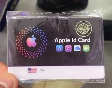 عبوة بلاستيكية مغلقة فيها بطاقة عنوانها Apple Id Card، عليها شعار آبل وأيقونات App Store وMusic وiCloud وFaceTime وعلم الولايات المتحدة وختم كُتب عليه The Original.